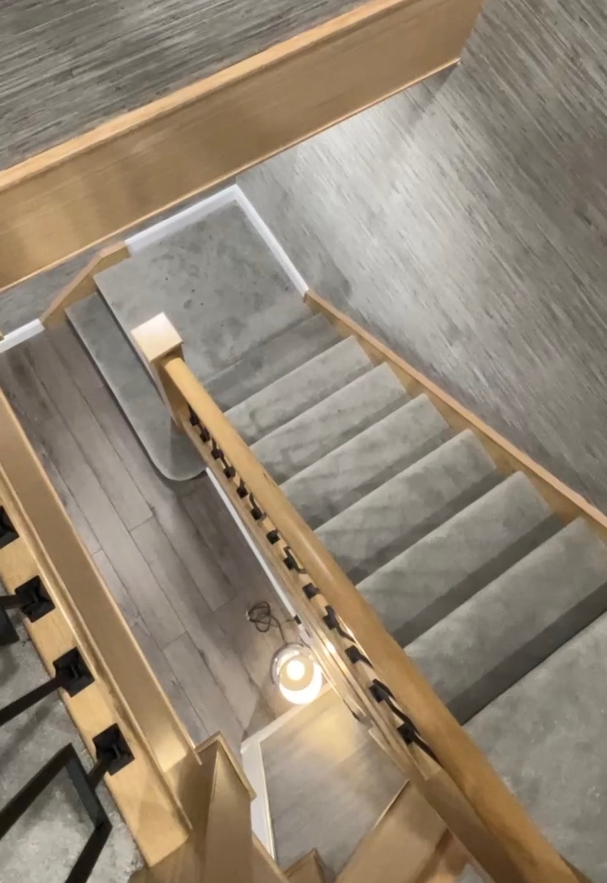 Overhead view of staircase with grey carpet and oak handrail