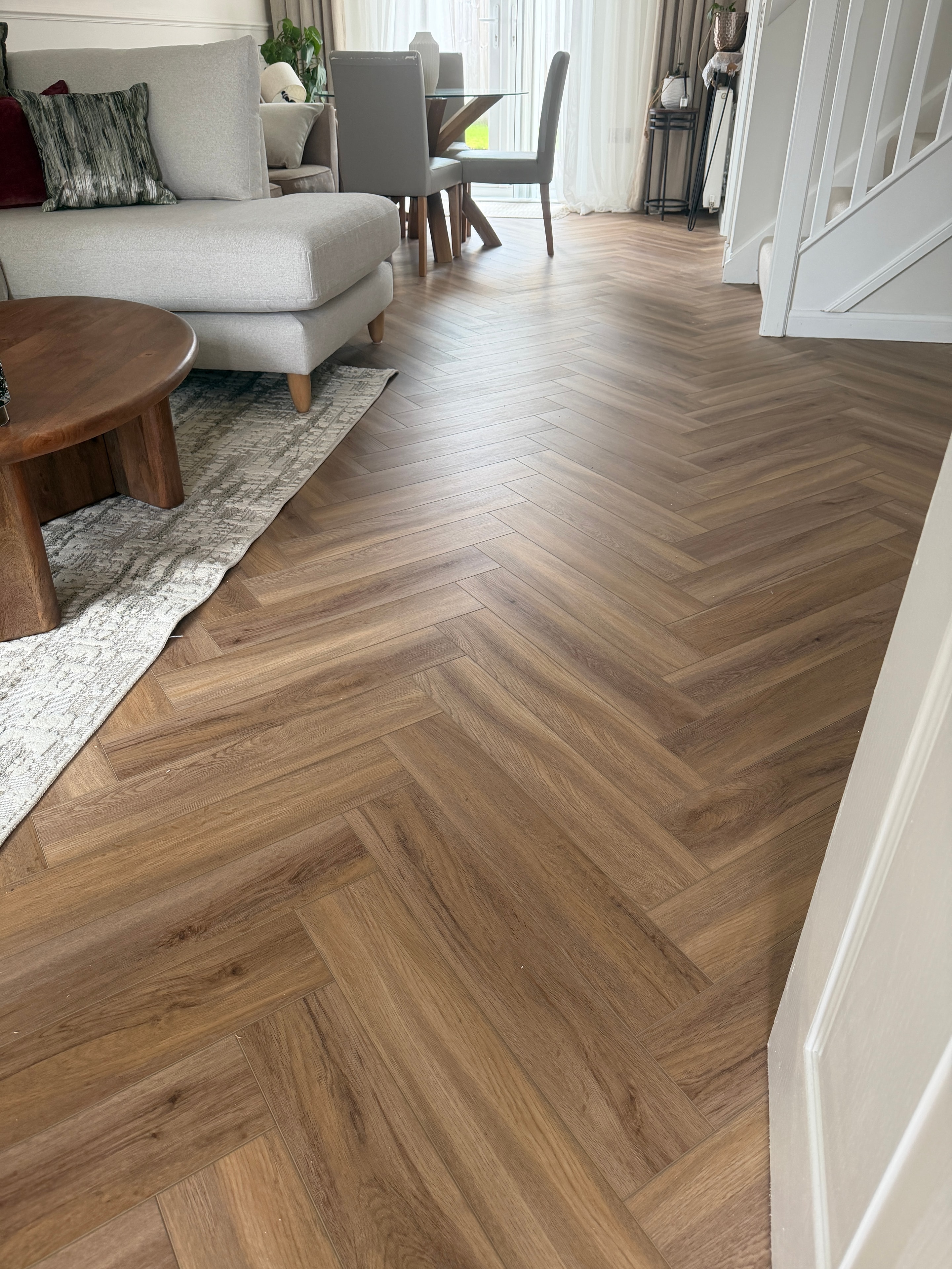Open plan living and dining area with herringbone LVT flooring